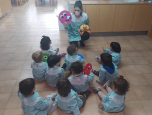 Profesora de inglés de la escuela en el aula con alumnos infantil